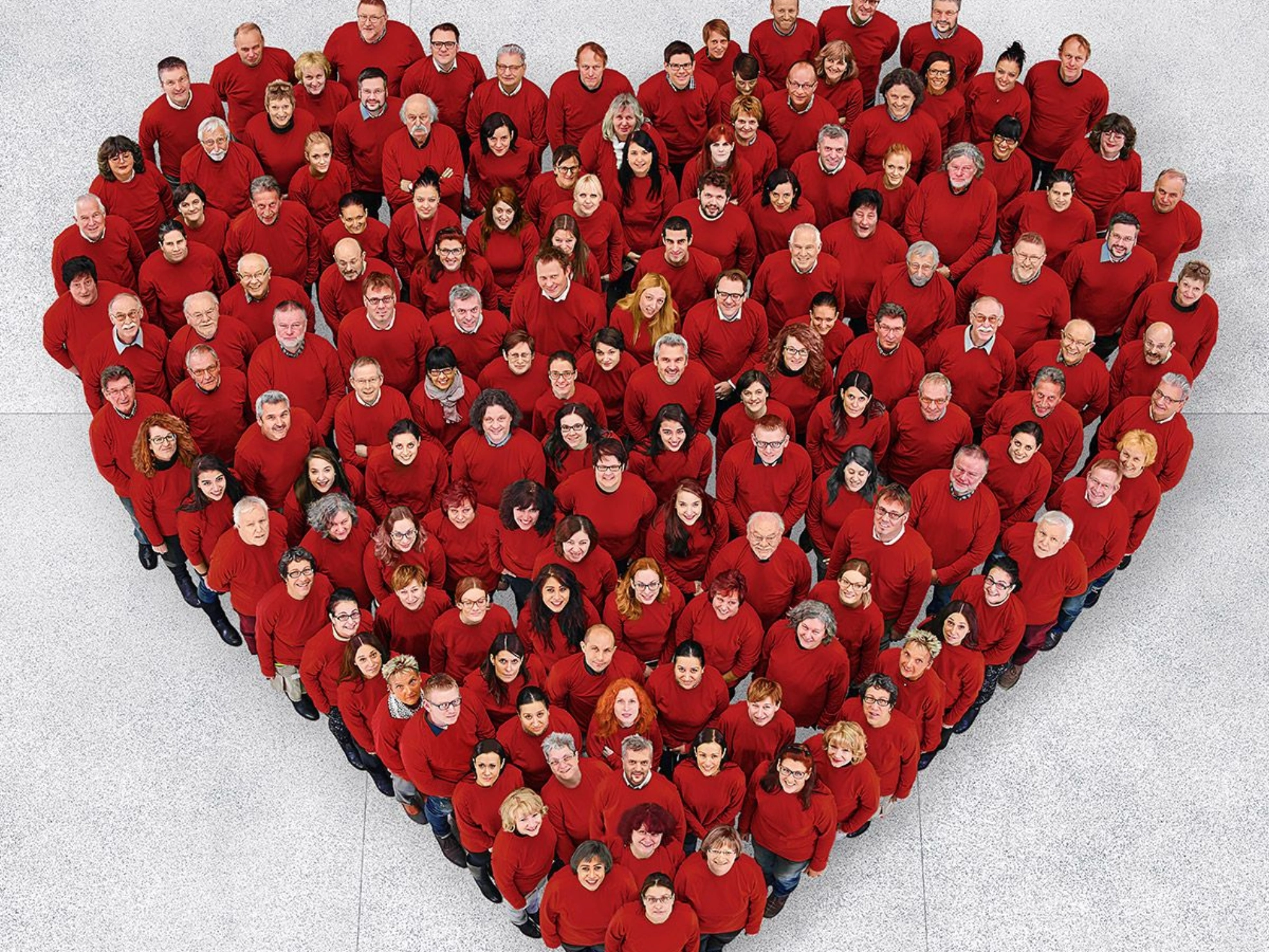 Beschäftigte stehen zu einem großen Herz zusammen