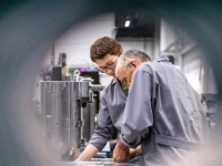 Ein älterer und ein jüngerer Arbeitnehmer in einem Betrieb.