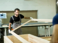 Junge Männer arbeiten in einer Fabrik zur Möbelherstellung.